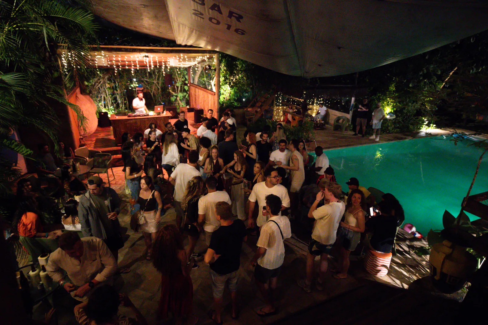 Festa à beira da piscina no Floresta Bar, com DJ e o veleiro ao fundo