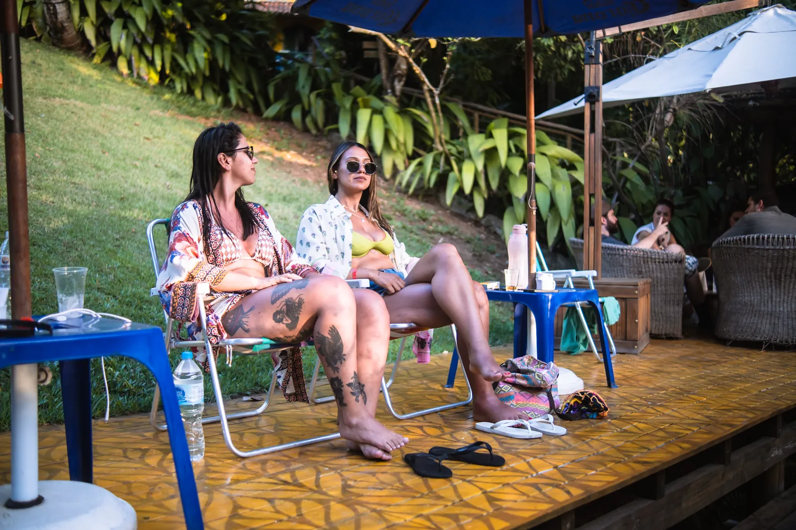 Hóspedes relaxando nas espreguiçadeiras do deck da piscina do Hostel da Vila em Ilhabela